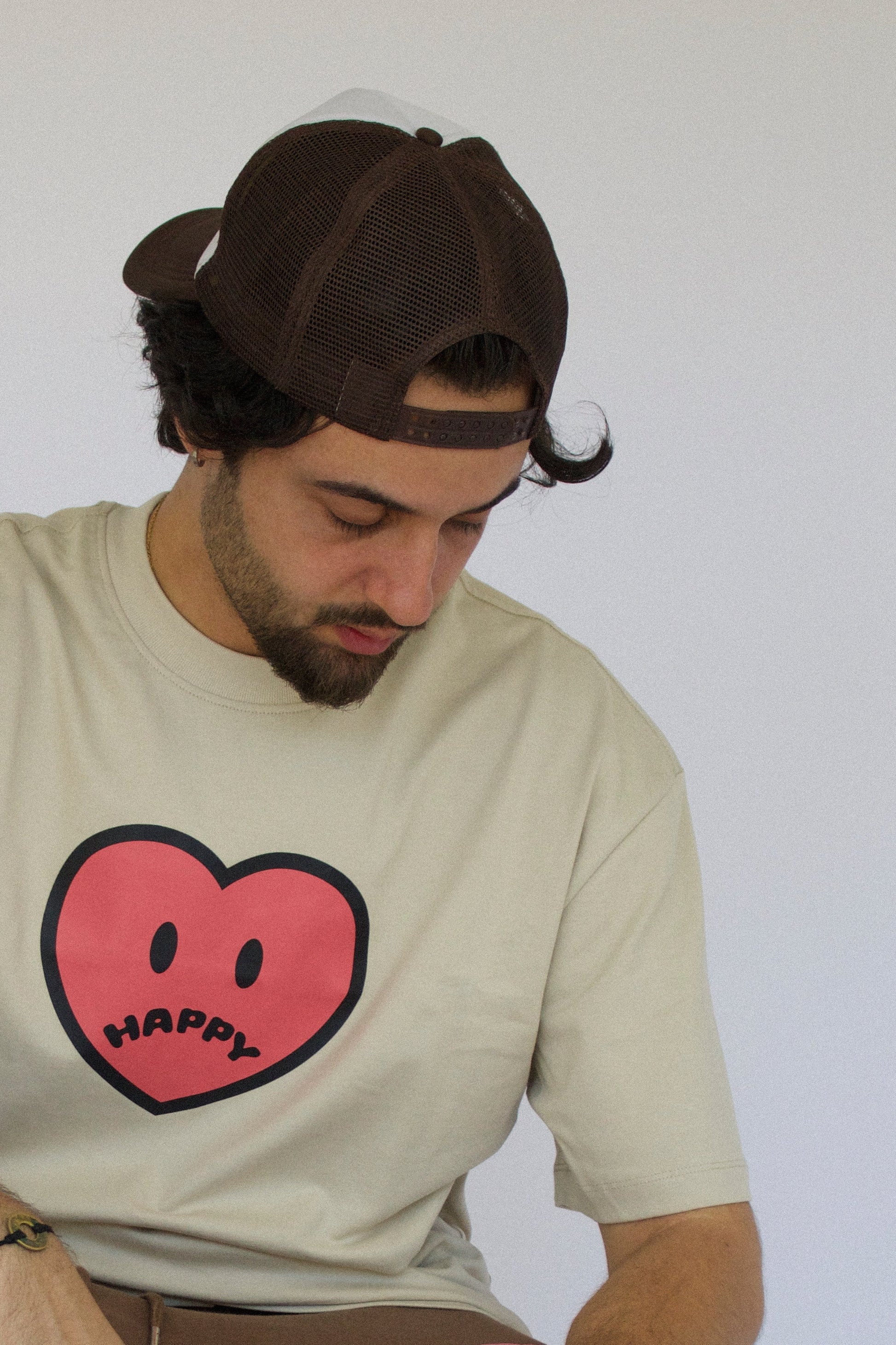 Model wearing Happy Home chocolate trucker hat — streetwear brand supports NAMI