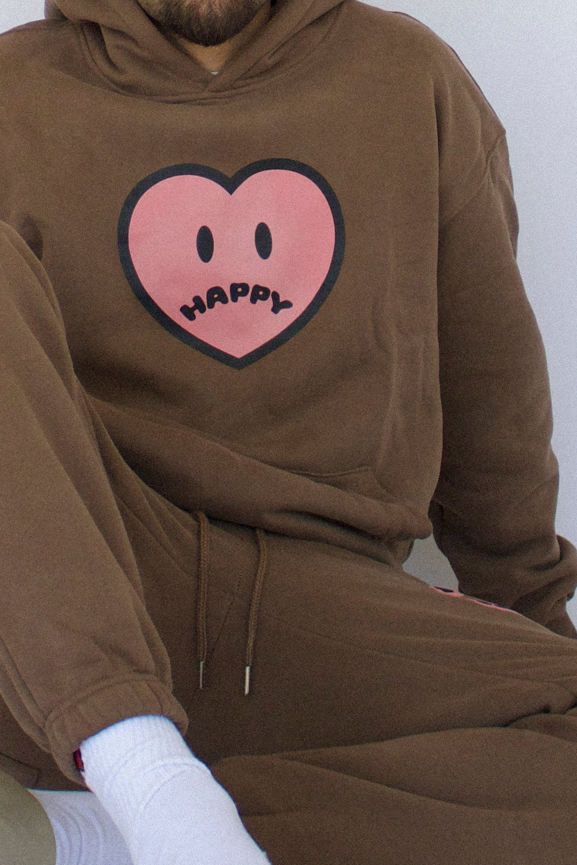 Happy Home chocolate hoodie on model — limited 240-piece drop earthy colorway