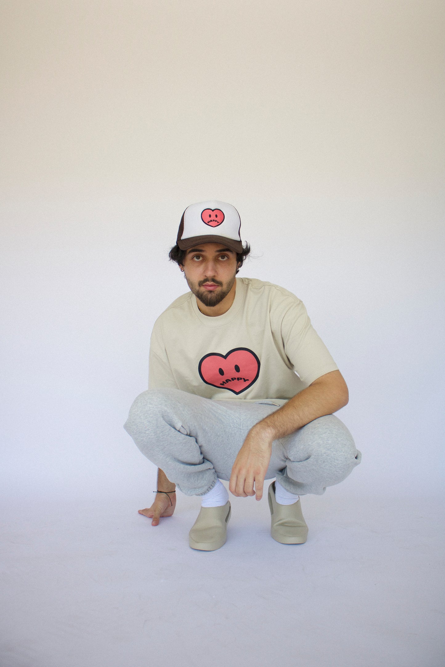 Model wearing Happy Home sand tee — founder-owned minimal streetwear brand
