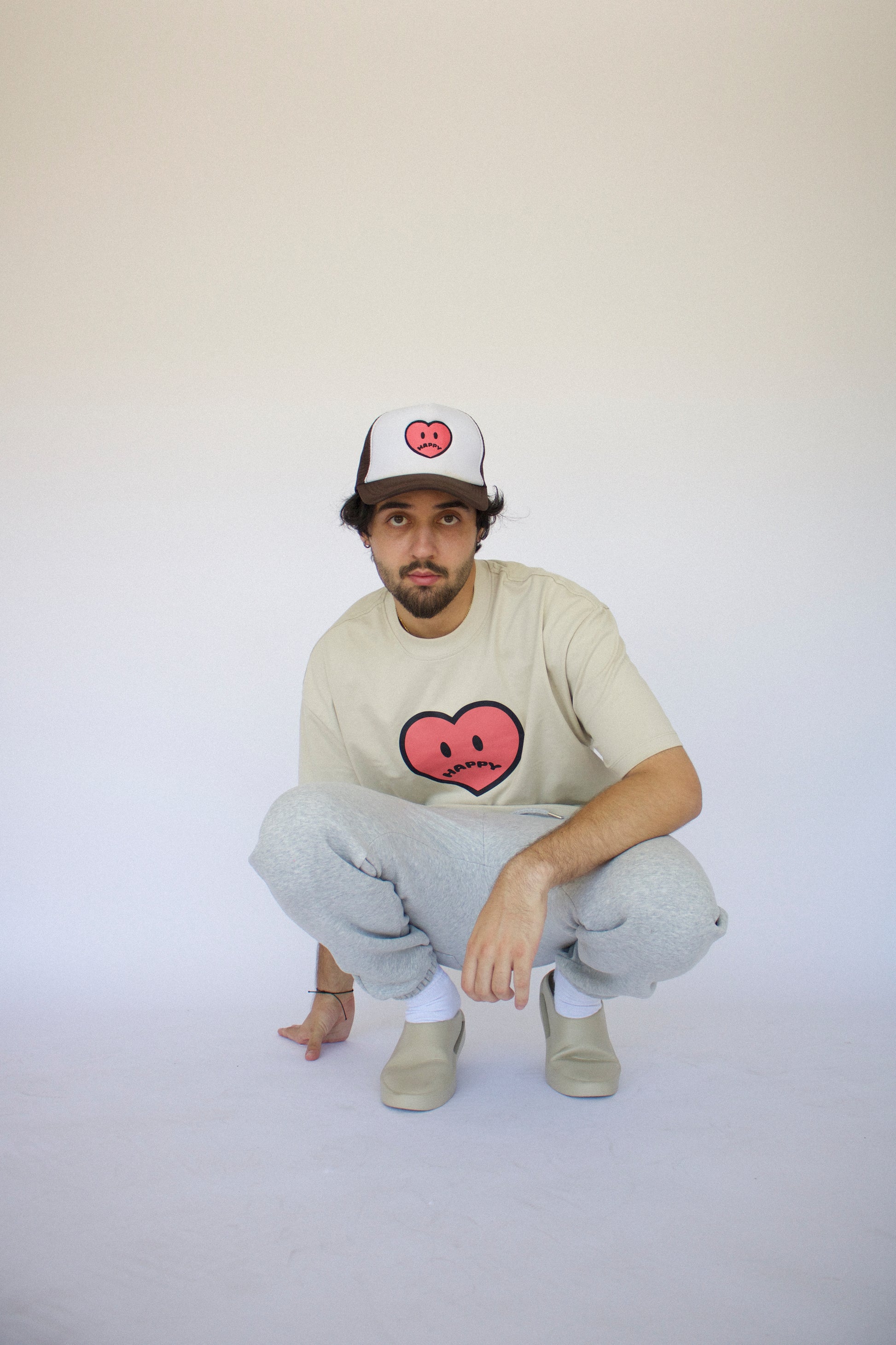 Model wearing Happy Home sand tee — founder-owned minimal streetwear brand